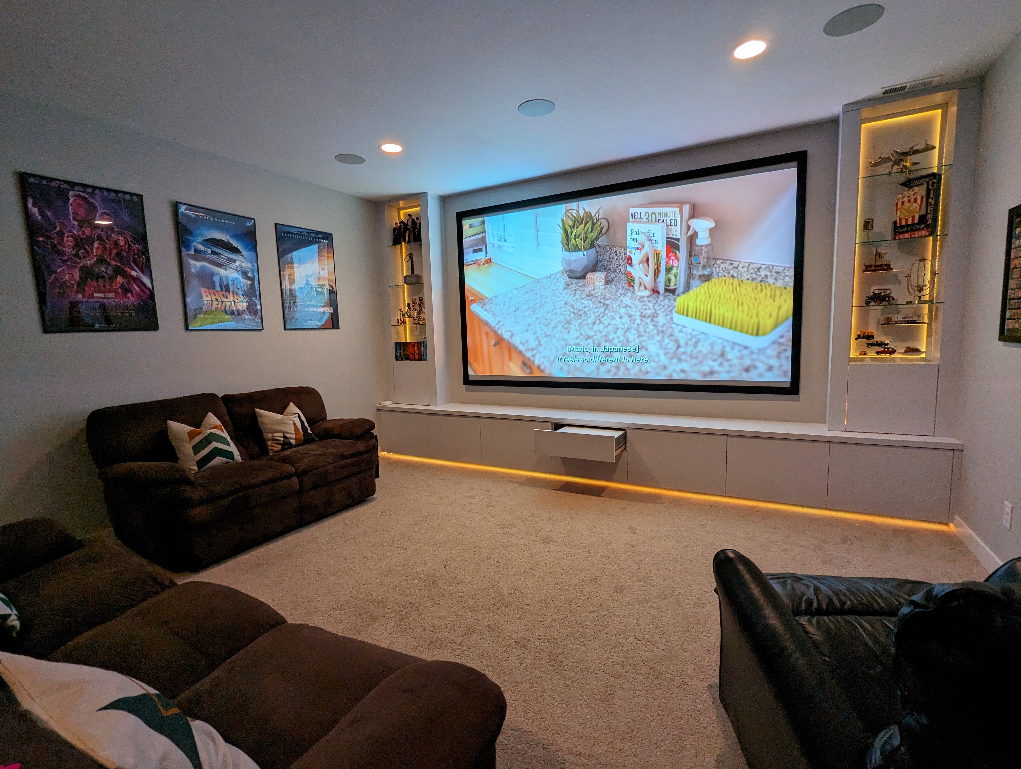 Home theatre incorporating seamless projector housing, backlit display and favorite movie posters
